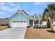 Charming home featuring a three-car garage, dormer windows, teal siding, and a well-manicured front yard at 3115 Cross Vine Ln, Summerville, SC 29483