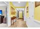 Welcoming foyer with eye-catching yellow walls, wood flooring, and seamless transition into adjoining rooms at 3115 Cross Vine Ln, Summerville, SC 29483