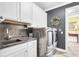Well-appointed laundry room with sleek gray countertops and modern stainless steel washer and dryer at 3115 Cross Vine Ln, Summerville, SC 29483