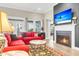 Cozy living room with a fireplace, large TV, and comfortable seating for relaxing and entertaining at 3115 Cross Vine Ln, Summerville, SC 29483