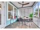 Cozy screened porch with a ceiling fan, blinds, and a comfortable outdoor seating area at 3115 Cross Vine Ln, Summerville, SC 29483