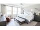 Bright bedroom features a large bed with soft white linens and a sitting area by the three large windows at 338 Hillman Trail Dr, Moncks Corner, SC 29461