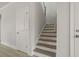 Neutral staircase with wood treads and painted risers, adjacent to a storage closet at 346 Hillman Trail Dr, Moncks Corner, SC 29461