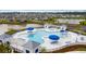 Aerial view of a community pool with lounging areas, blue umbrellas and chairs near a lake at 350 Bering Ln, Summerville, SC 29486