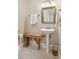 Classic half bathroom with a pedestal sink, gold mirror, and vintage wooden bench at 3619 Loggerhead Ct, Seabrook Island, SC 29455