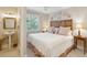 Bright bedroom featuring a decorative wooden headboard, a window and a sink in the adjacent bathroom at 3619 Loggerhead Ct, Seabrook Island, SC 29455