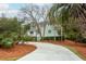 Charming two-story home with lush landscaping, curved driveway, and welcoming front porch at 3619 Loggerhead Ct, Seabrook Island, SC 29455