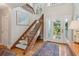 Bright foyer featuring hardwood floors, a wooden staircase with carpeted steps, and a door leading to the outside at 3619 Loggerhead Ct, Seabrook Island, SC 29455
