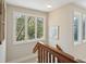 Hallway with wooden banister and bright windows offering ample natural light and serene outdoor views at 3619 Loggerhead Ct, Seabrook Island, SC 29455