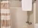 Bathroom shower features neutral striped curtain, mounted shower head, and adjustable hose at 40 Bee St # 112, Charleston, SC 29403
