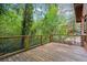 View of wooden back deck with wooden railing surrounded by trees at 415 W Carolina Ave, Summerville, SC 29483