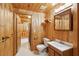 Traditional bathroom featuring wood walls, a single sink vanity, toilet, and medicine cabinet at 415 W Carolina Ave, Summerville, SC 29483