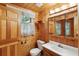 Traditional bathroom featuring wood plank walls, a single sink vanity, toilet, and medicine cabinet at 415 W Carolina Ave, Summerville, SC 29483