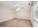 Neutral carpeted bedroom featuring a ceiling fan and window with blinds at 415 W Carolina Ave, Summerville, SC 29483