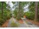 Inviting long driveway leading to a charming cabin-style home surrounded by mature trees at 415 W Carolina Ave, Summerville, SC 29483