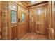Warm, wood-paneled entryway featuring three doors, showcasing the cabin's rustic charm at 415 W Carolina Ave, Summerville, SC 29483