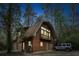 Unique barn-style home with a second-story balcony, multi-car garage, and wooded surroundings creates an eye-catching, secluded setting at 415 W Carolina Ave, Summerville, SC 29483