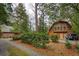 Charming log cabin home with lush landscaping, a gravel driveway, and a Jeep at 415 W Carolina Ave, Summerville, SC 29483