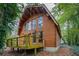 Charming two-story log cabin featuring a cozy deck nestled among lush greenery at 415 W Carolina Ave, Summerville, SC 29483