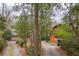Charming log cabin home with lush landscaping, a gravel driveway, and a Jeep at 415 W Carolina Ave, Summerville, SC 29483