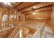 Spacious hallway with wood floors and wood plank walls, with an upper-level landing showcasing log beam construction at 415 W Carolina Ave, Summerville, SC 29483