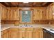 Rustic kitchen with wood cabinets, laminate countertops, stainless sink, and view to the outdoors at 415 W Carolina Ave, Summerville, SC 29483