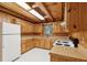 Rustic kitchen with wood cabinets, laminate countertops, and white appliances at 415 W Carolina Ave, Summerville, SC 29483