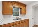 Kitchen features wooden cabinets, stainless steel sink, and white countertops at 415 W Carolina Ave, Summerville, SC 29483
