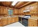 Rustic kitchen with wood cabinets, laminate countertops, and black appliances at 415 W Carolina Ave, Summerville, SC 29483