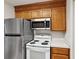 Kitchen features stainless steel refrigerator, white microwave, and white stove at 415 W Carolina Ave, Summerville, SC 29483
