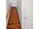 Wooden stairway with a white painted wall, door and handrail leading to the upper level at 415 W Carolina Ave, Summerville, SC 29483