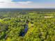 Scenic aerial shot of a heavily wooded area with a pond, a home, and nearby country roads at 4304 River Rd, Johns Island, SC 29455