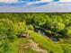 Scenic aerial view of lush property featuring a pond, mature trees, and rustic outbuildings at 4304 River Rd, Johns Island, SC 29455