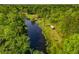 Aerial view of property with pond, mature trees, parked RV, and various outbuildings at 4304 River Rd, Johns Island, SC 29455