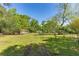 View of a large backyard, mature trees, and various outbuildings in a rural setting at 4304 River Rd, Johns Island, SC 29455