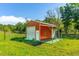 View of a red barn with metal roof and attached carport, creating functional outdoor space at 4304 River Rd, Johns Island, SC 29455