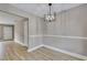 Dining area featuring wood-look floors, a modern light fixture, neutral paint, and white trim at 515 Travelers Blvd, Summerville, SC 29485