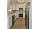 Well-lit kitchen featuring white cabinets, granite countertops, wood-look floors, and stainless steel appliances at 515 Travelers Blvd, Summerville, SC 29485