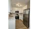 Modern kitchen with white cabinets, stainless steel appliances, granite countertops, and wood-look floors at 515 Travelers Blvd, Summerville, SC 29485