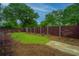 Landscaped backyard with lawn, mulch, and a stained horizontal privacy fence at 616 W 2Nd N St, Summerville, SC 29483