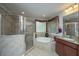Well lit bathroom featuring a glass enclosed shower, soaking tub, and granite countertops at 616 W 2Nd N St, Summerville, SC 29483