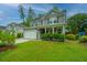 Inviting two-story home with a well-maintained lawn, attached garage, and a basketball hoop at 616 W 2Nd N St, Summerville, SC 29483