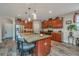 Kitchen boasts granite island with seating, stainless appliances, rich wood cabinetry, and wood-look floors at 616 W 2Nd N St, Summerville, SC 29483