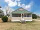 Charming front exterior featuring a quaint front porch, green metal roof, and tidy landscaping at 6760 Yemassee Hwy, Varnville, SC 29944