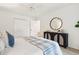 Bright bedroom with white walls features a decorative black cabinet, large mirror, and a cozy bed at 935 Paul Revere Dr, Charleston, SC 29412