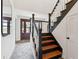 Bright entryway features a wooden staircase and front door, stone floors, and a decorative mirror at 935 Paul Revere Dr, Charleston, SC 29412