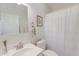 Bright bathroom features a white vanity, mirror, towel rack, toilet, and shower with white curtain at 949 E Estates Blvd # 303, Charleston, SC 29414