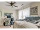 Comfortable bedroom with a ceiling fan, computer desk, and curtained window for soft natural light at 949 E Estates Blvd # 303, Charleston, SC 29414