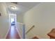 Hallway with red wood flooring, white walls, and a stairway with light-colored wooden handrail at 949 E Estates Blvd # 303, Charleston, SC 29414