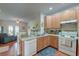 Well-lit kitchen with wooden cabinetry, white appliances, and view into the living room at 949 E Estates Blvd # 303, Charleston, SC 29414